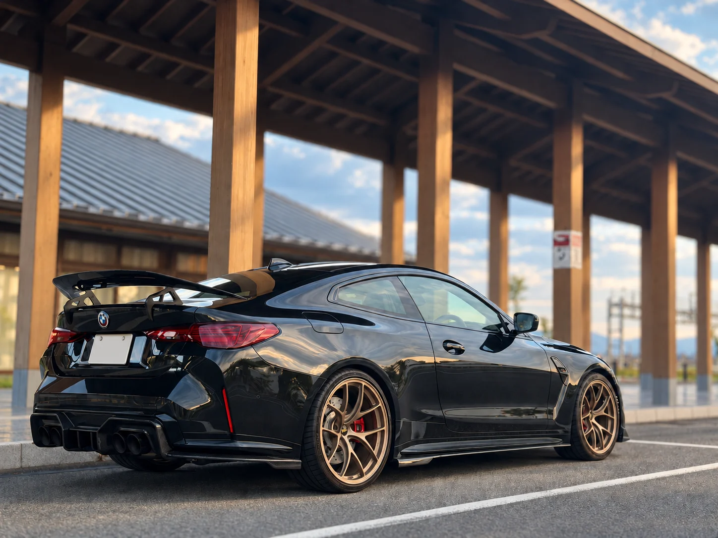 Rear view of a black BMW under a timber pavilion
